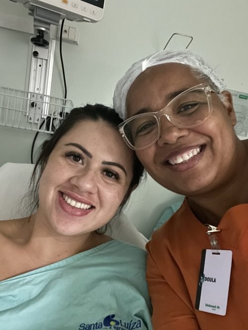 Sorriso de missão cumprida: mãe e doula lado a lado.